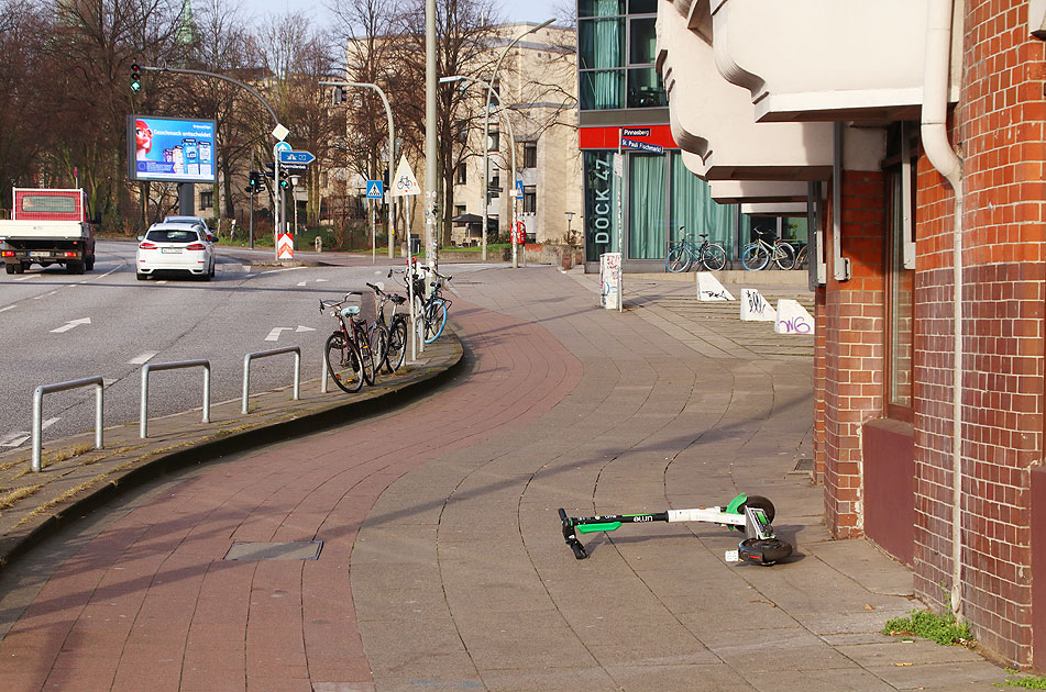 Ein E-Scooter - Elektroroller liegt auf einem Gehweg