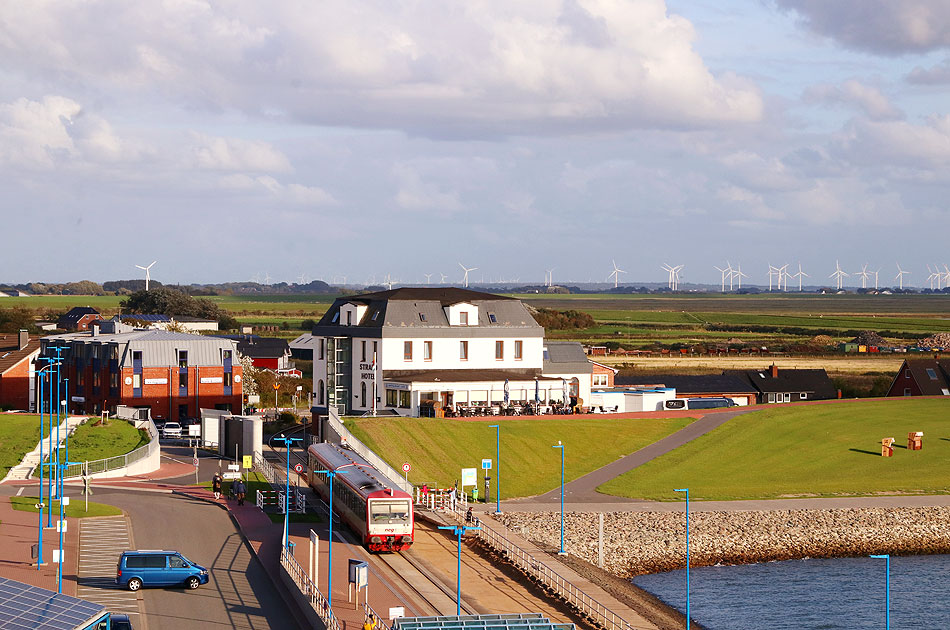 Ein Zug der NEG in Dagebüll Mole mit dem Strandhotel und Deich