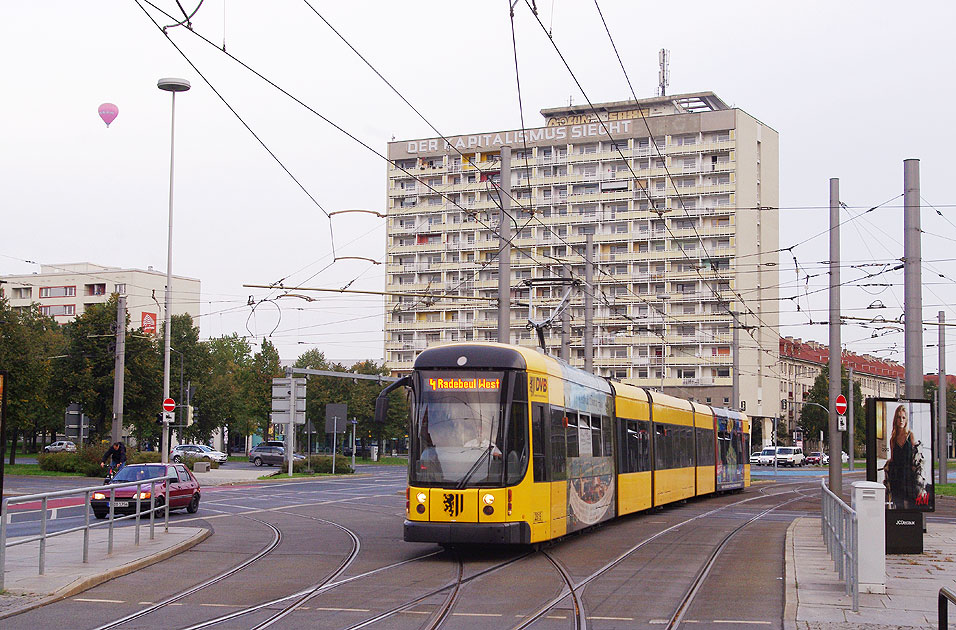 Im Hintergrund das markante Hochhaus Pirnaischer Platz: Straßenbahn Dresden - Haltestelle Pirnaischer Platz - Hochhaus - Der Sozialismus siegt - Der Kapitalismus siecht