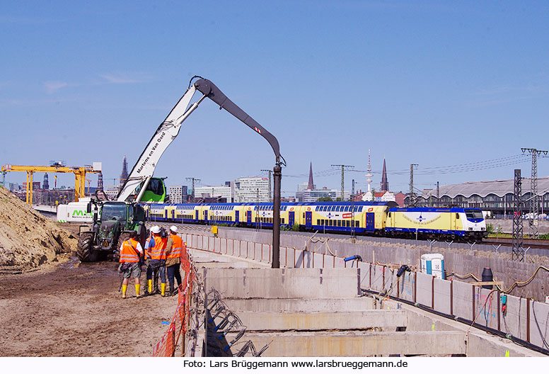 Ein Metronom auf der Pfeilerbahn neben der Baustelle für die Hafencity U-Bahn